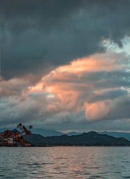 Peaceful Hawaiian sunset with clouds over ocean and mountains. Perfect serene landscape.