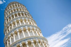 Iconic Leaning Tower of Pisa under a blue sky, a symbol of Italian architecture and history.