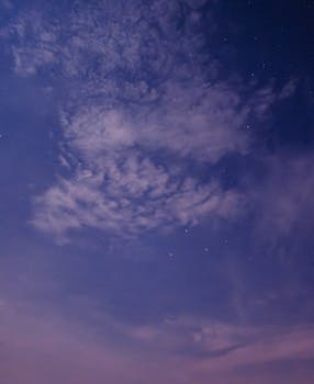 Explore the tranquil beauty of a starry night sky with subtle cloud formations in Malaysia.
