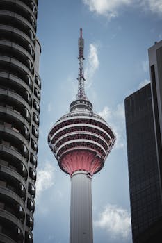 Stunning view of Menara Kuala Lumpur framed by modern buildings in Malaysia.