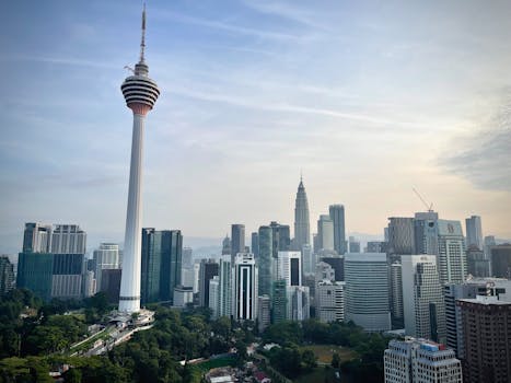 Dramatic view of Kuala Lumpur's skyline featuring the iconic Menara Tower.
